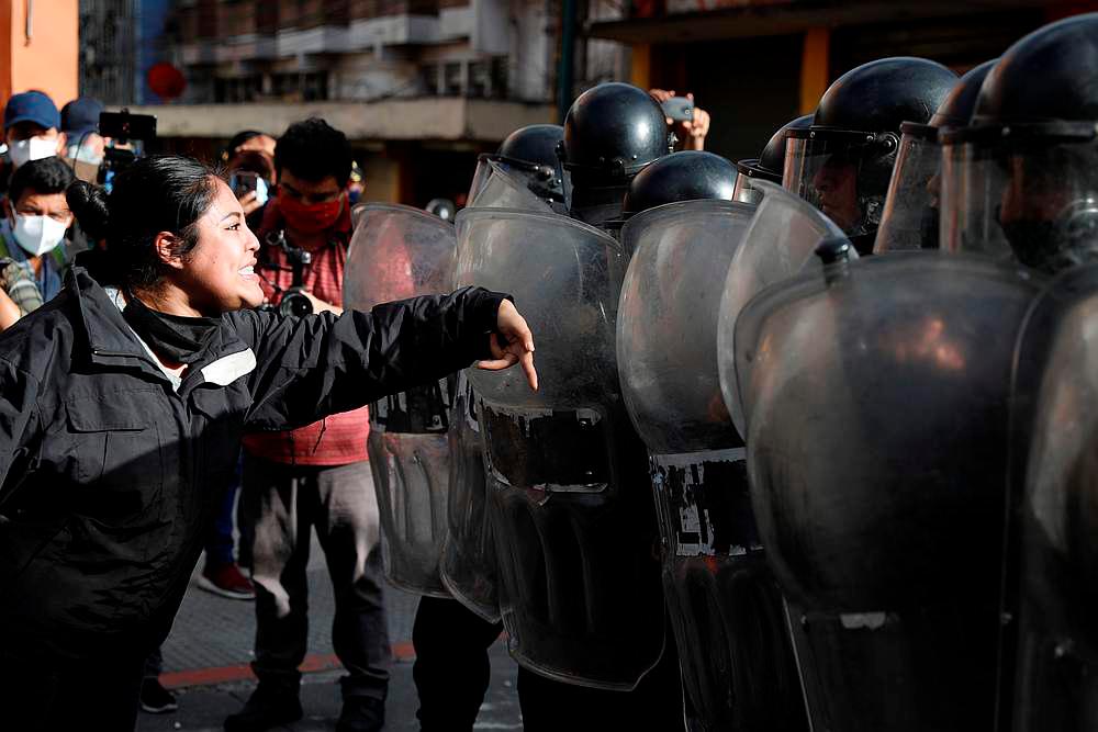 A demonstrator shouts at riot police during a protest demanding the resignation of President Alejandro Giammattei, in Guatemala City, Guatemala November 21, 2020. —— Reuters