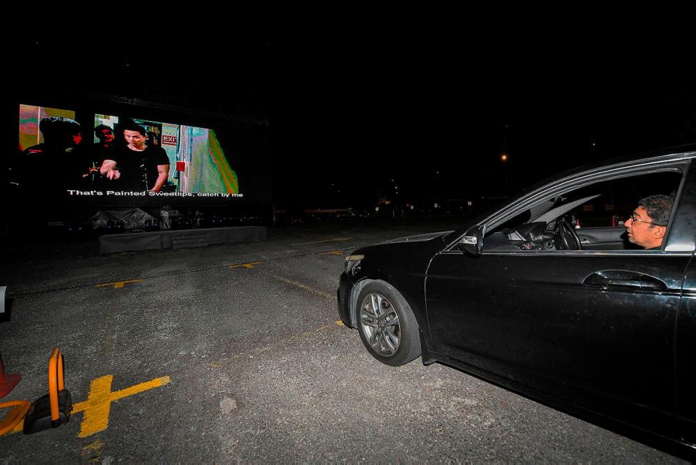 Deputy Minister of Communications and Multimedia Datuk Zahidi Zainul Abidin watched a movie from inside of a car during the opening ceremony of the CineDrive drive-in cinema, last night.-Bernama