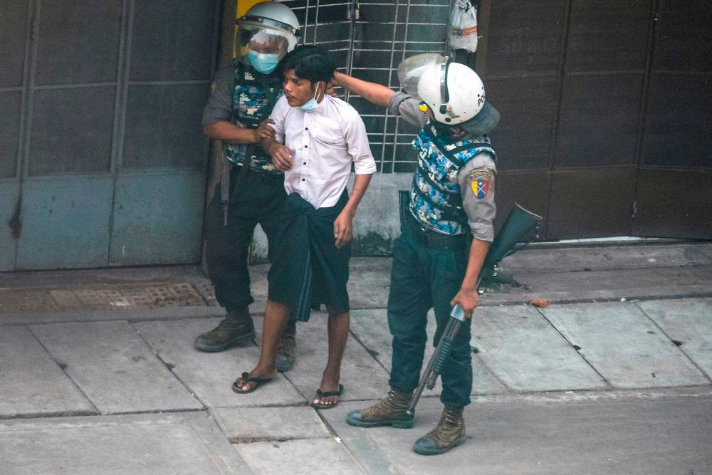 Riot police officers detain a demonstrator during a protest against the military coup in Yangon, Myanmar, March 19, 2021. — Reuters