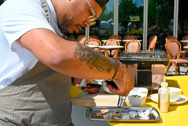 Jerome Grant, seen plating a dish at his Washington bistro Jackie, remembers well his experiences of racism in the kitchen. — AFP