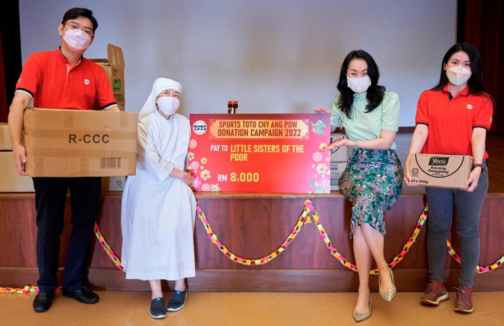 Sports Toto executive director Nerine Tan (second from right) with Toto volunteers handing over the presentation cheque and food provision to Sister Maria Angela, the representative from Pusat Jagaan Little Sisters of the Poor.