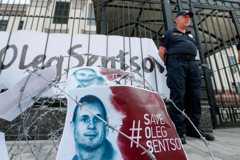 Barbed wire and placards with images of Ukrainian film director Oleg Sentsov are seen after a rally demanding the release of Sentsov, who was jailed on terrorism charges and is currently on hunger strike in Russian jail, in front of the Russian embassy in Kiev, Ukraine August 21, 2018. — Reuters
