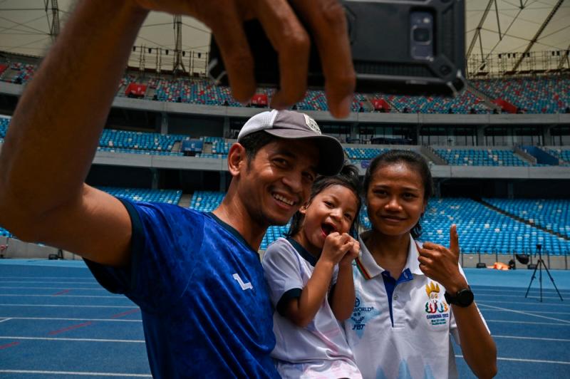 Cambodia’s Bou Samnang (right) takes a selfie with people at the 32nd SEA Games (Southeast Asian Games) in Phnom Penh//AFPix