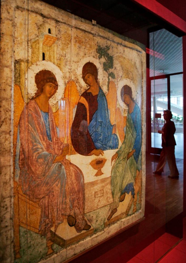 A woman passes behind the Trinity icon by Andrei Rublev at the Tretyakov picture gallery in Moscow//AFPix