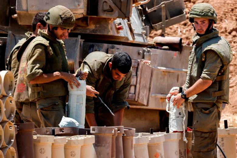 Israeli soldiers check artillery shells in an area near the border with Gaza, in southern Israel, May 13, 2021. -Reuters