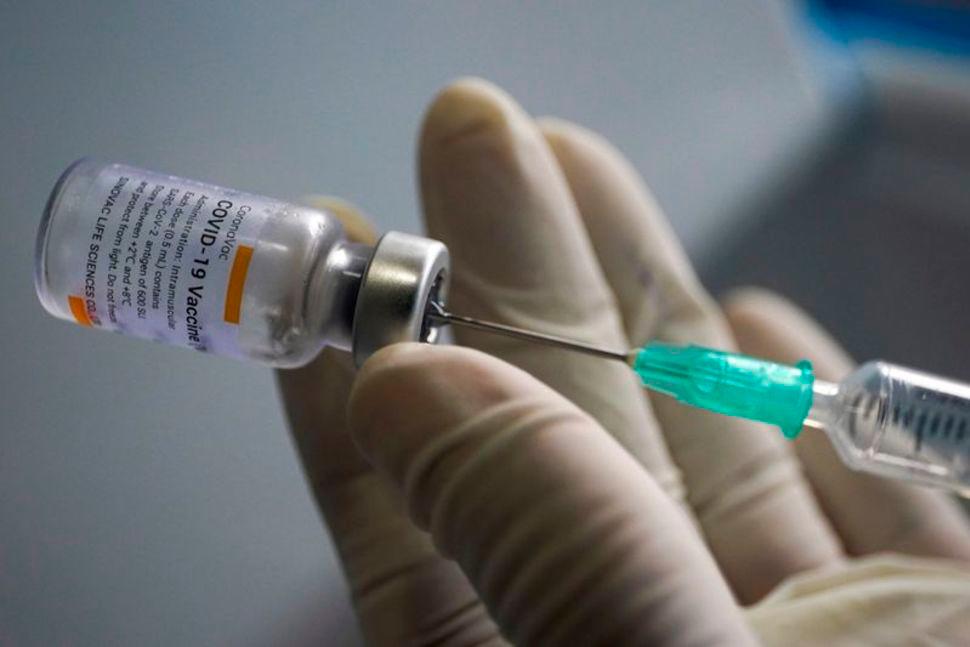 A health worker holds a syringe and a vial of the Sinovac coronavirus disease (Covid-19) vaccine at a market in Bangkok, Thailand, March 17, 2021. -REUTERSPix