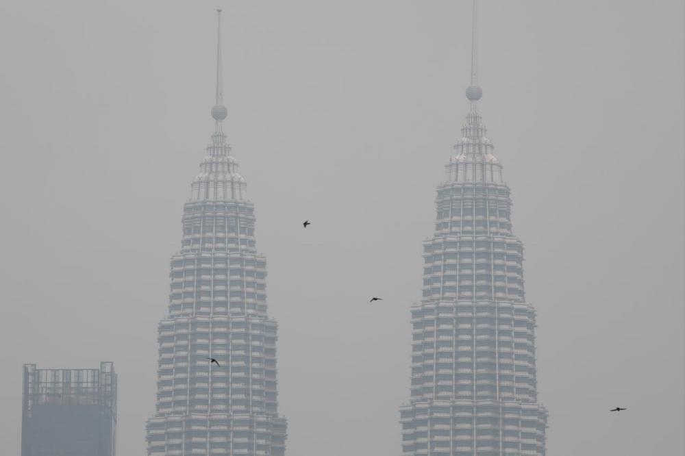 Petronas Twin Towers shrouded by haze in Kuala Lumpur yesterday. — Reuters