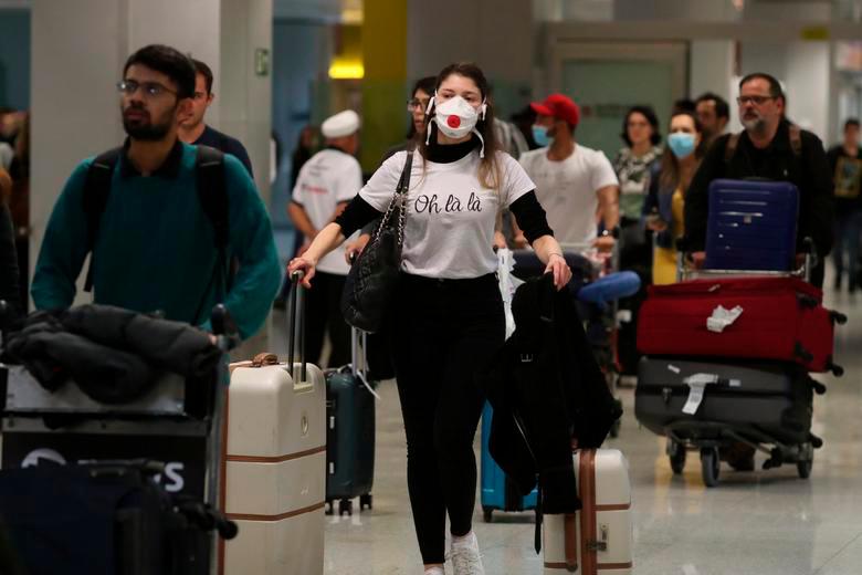 A traveller, wearing a mask as a precautionary measure to avoid contracting coronavirus, arrives on a flight from Europe at Guarulhos International Airport in Guarulhos, Sao Paulo state, Brazil, February 27, 2020. REUTERSPIX