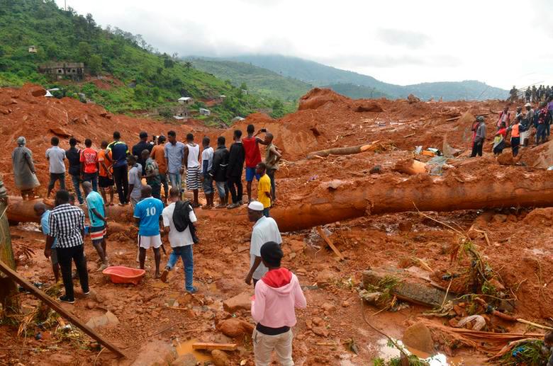 Residents stand as rescue workers search for survivors after a mudslide in the mountain town of Regent, Sierra Leone. REUTERSPIX