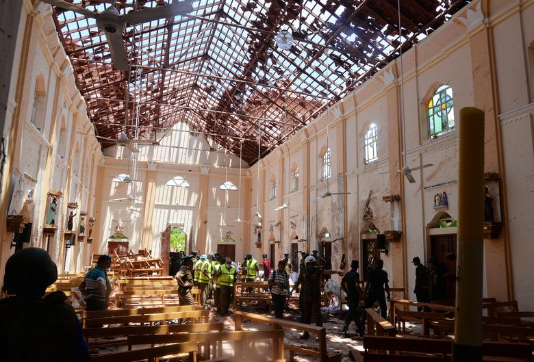 Crime scene officials inspect the site of a bomb blast inside a church in Negombo, Sri Lanka, April 21. — Reuters