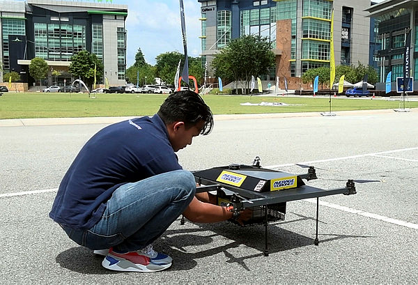 An engineer from Average Drone Sdn Bhd exhibiting the drone used in the food delivery service on June 17 during Multimedia Technology week at Cyberjaya, Sepang. — Bernama