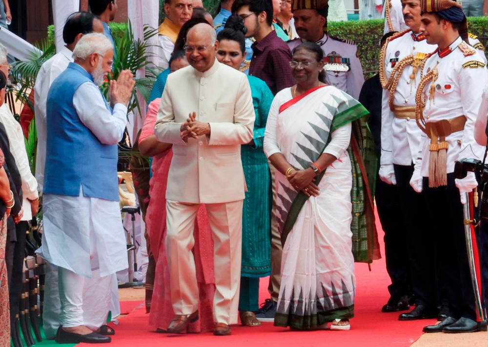 India's Prime Minister Narendra Modi greets outgoing president Ram Nath Kovind and new President Droupadi Murmu (right) after they both inspected an honour guard following Murmu's swearing-in ceremony. – REUTERSPIX