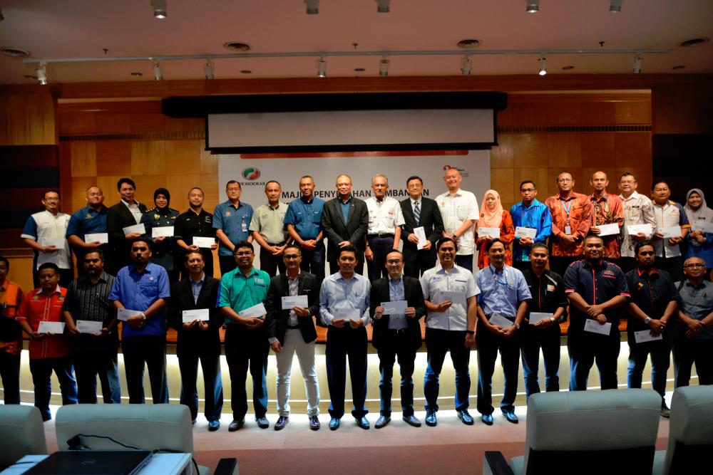 Aminar (top row, middle, in jacket) with representatives from the Fire and Rescue Department and HLIs during the handover ceremony. He is flanked by Perodua Sales Sdn Bhd managing director Datuk Zahari Husin (left) and Perodua Global Manufacturing Sdn Bhd president Datuk Ahmad Suhaimi Hashim (right).