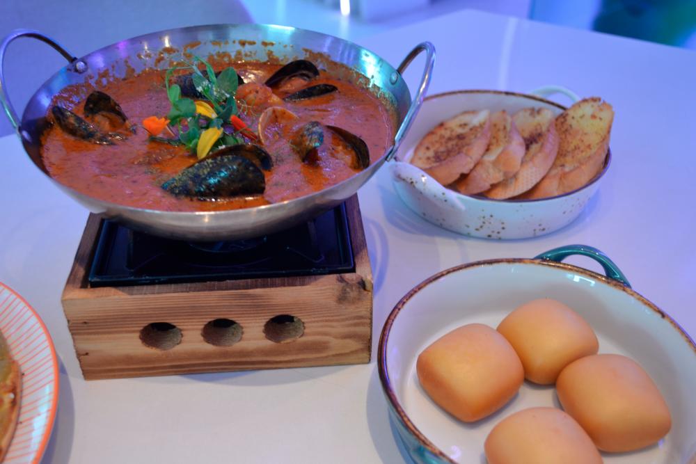 $!Mussels in a soup-style broth with the bright flavours of spicy pomodoro and olive paired with garlic bread, and fried mini mantao.