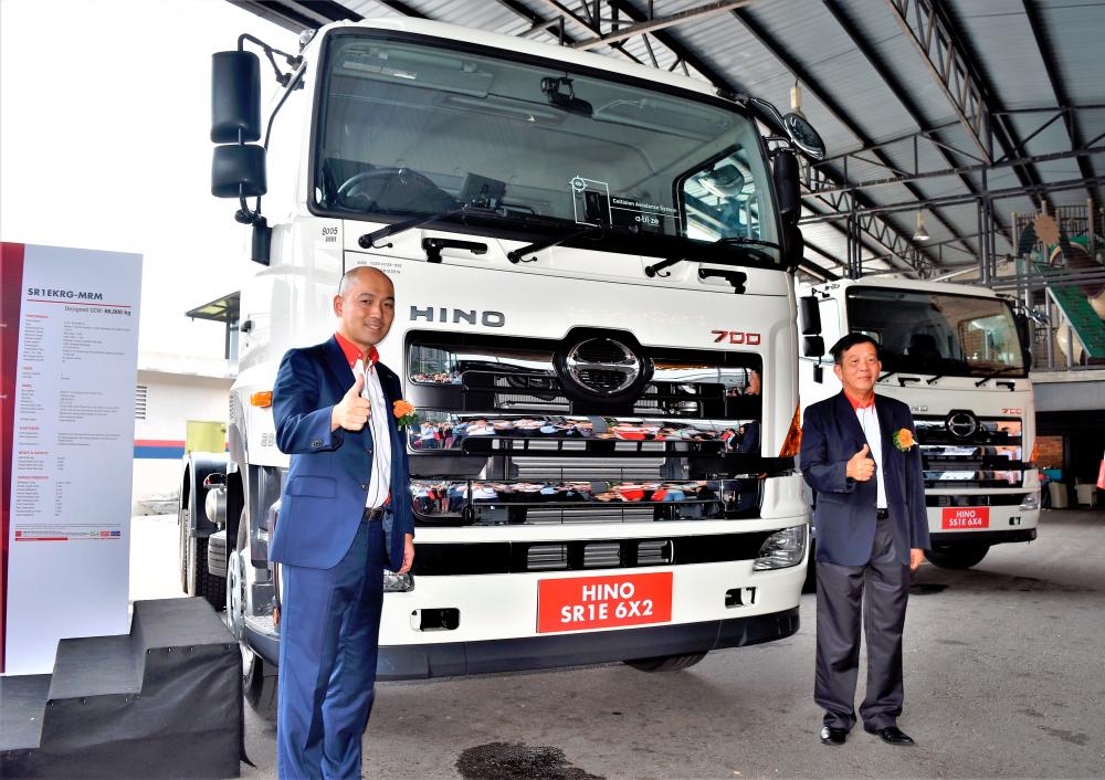 HMSM managing director Atsushi Uchiyama (left) and HMSM executive director Datuk Johnny Chan officially introducing the new variation of Hino 700 Series AMT models. Behind them is a SR1E 6x2 variant.