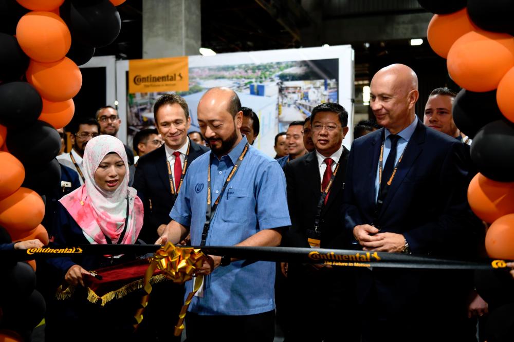 $!Mukhriz cutting a ribbon to officially inaugurate the plant, with Bernabe next to him.