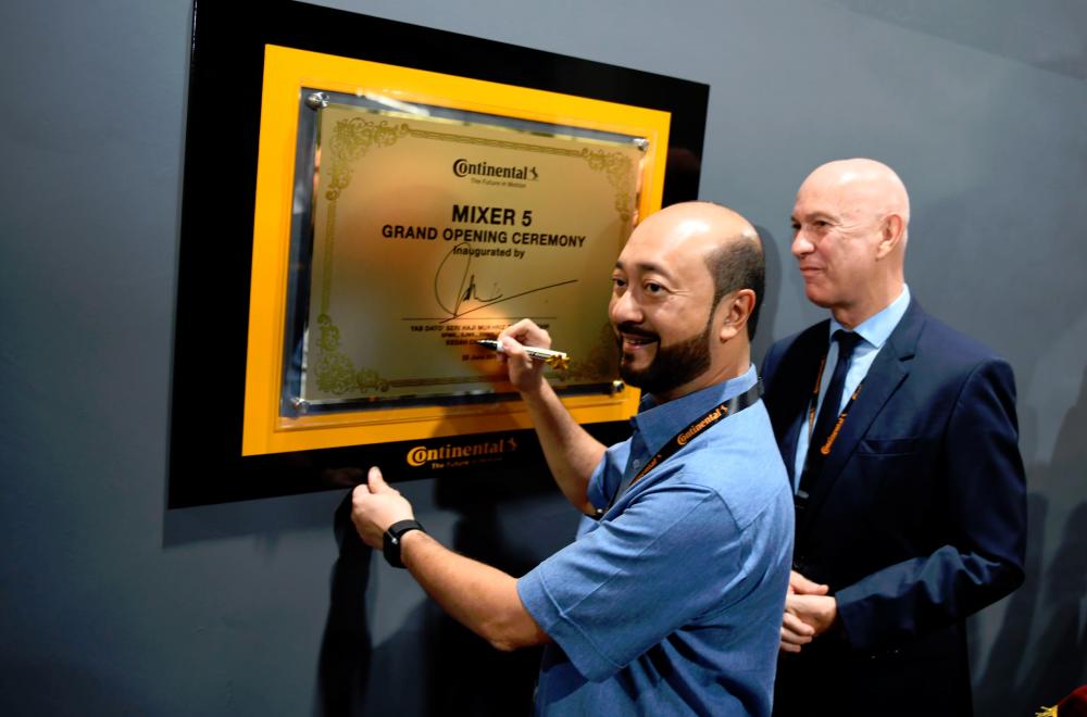 $!Mukhriz signing a commemorative plaque at the facility, while Bernabe looks on.