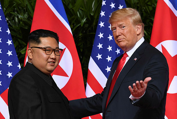 Photo shows US President Donald Trump (R) gestures as he meets with North Korea’s leader Kim Jong Un (L) at the start of their historic US-North Korea summit, at the Capella Hotel on Sentosa island in Singapore. — AFP