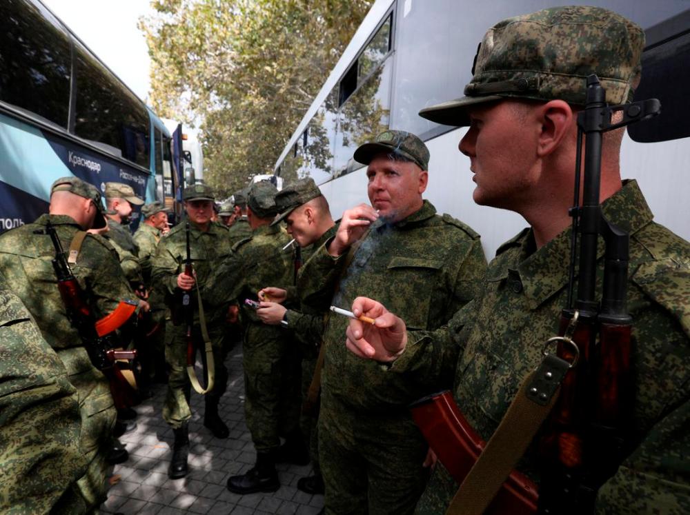 Reservists drafted during the partial mobilisation smoke next to buses as they depart for military bases, in Sevastopol, Crimea September 27, 2022. REUTERSPIX