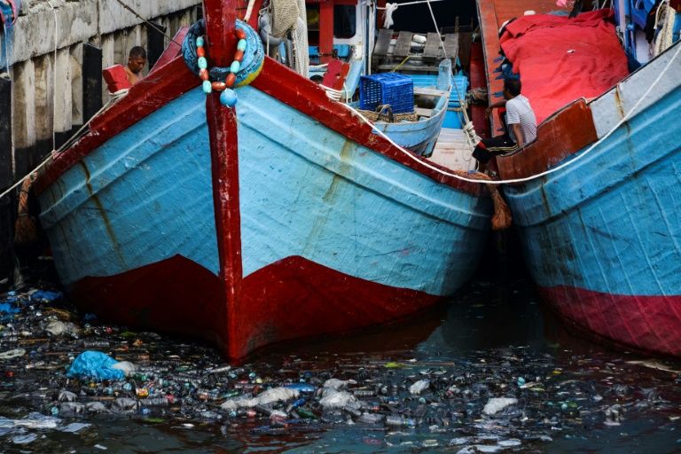 Fishing boats sit in trash-filled waters in Banda Aceh, Indonesia on July 16, 2019. — AFP