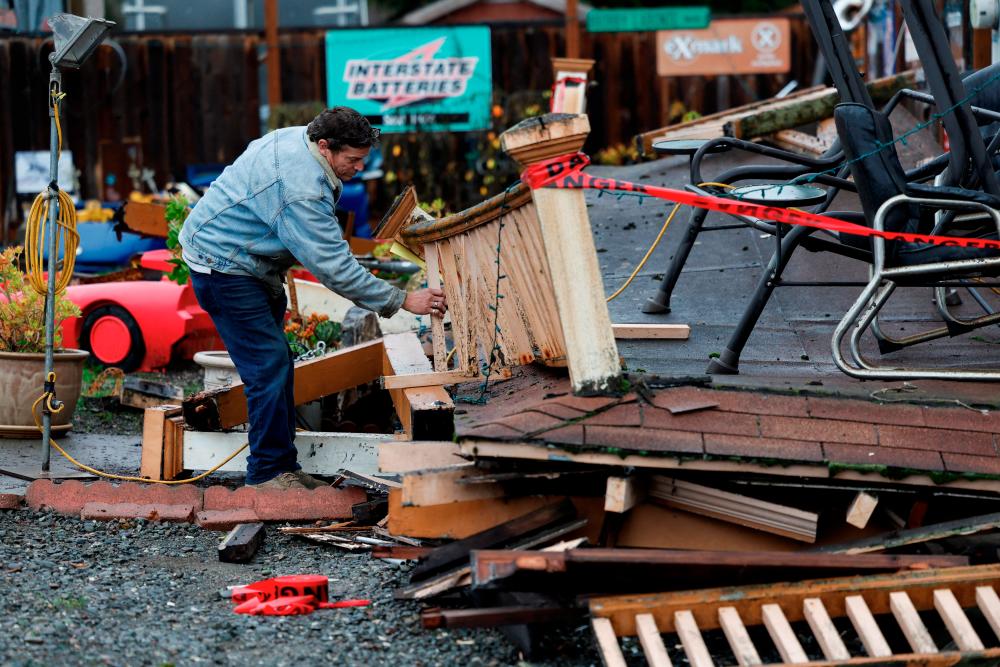 Homeowner Darren Gallagher inspects the collapsed second story porch of his house after a strong 6.4-magnitude earthquake struck off the coast of northern California, in Rio Dell, California, U.S. December 20, 2022. REUTERSPIX