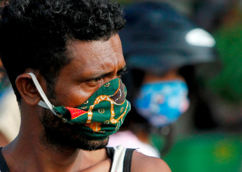 A vendor wearing a protective mask looks on as he waits for customers at a traditional market, after the government announced new cases of coronavirus disease (Covid-19), in Dili, East Timor, April 16, 2020. — Reuters