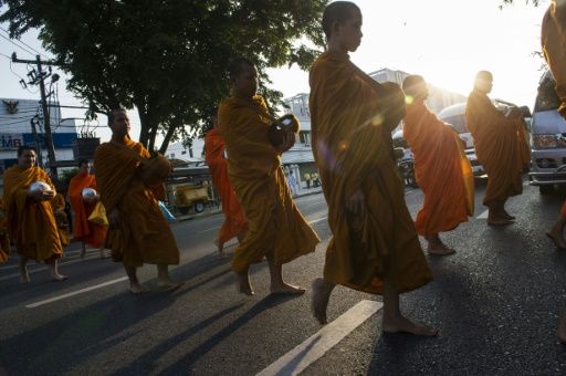 Thais seeking to earn merit and honour their ancestors often provide food to monks on their daily rounds but they can be generous to a fault. — AFP