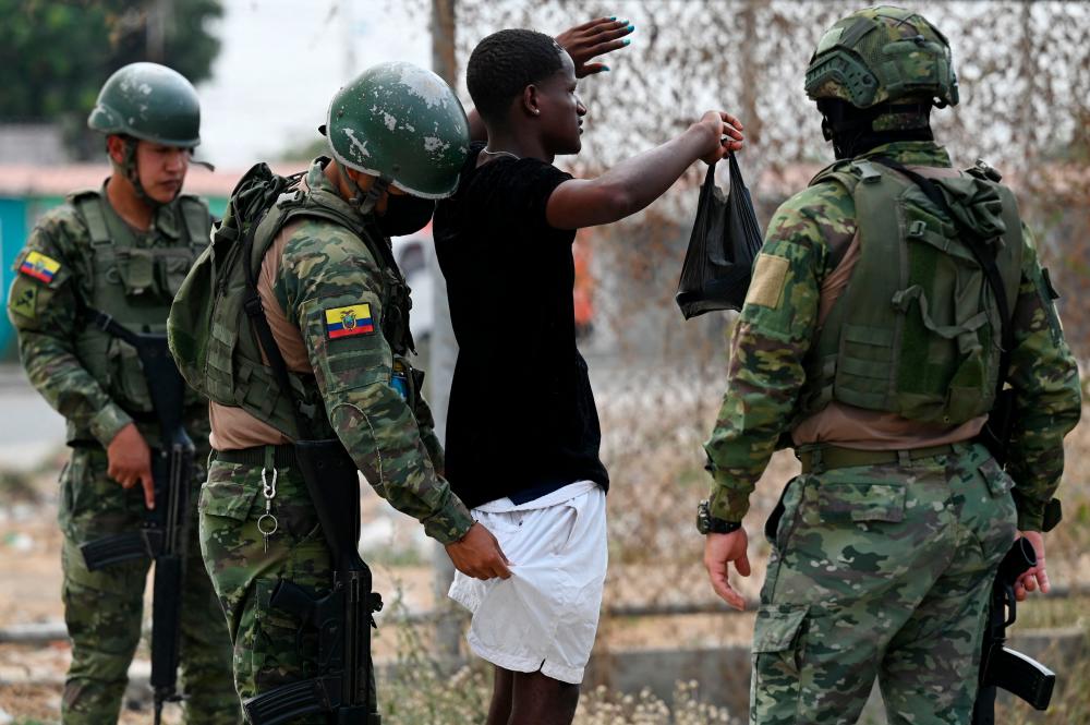 Soldiers check a man during a military operation at the Socio Vivienda 2 neighbourhood in Guayaquil, Ecuador, on October 10, 2022. AFPPIX