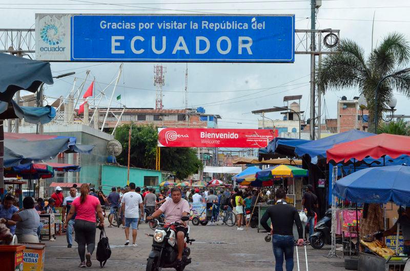 People walk and ride in Huaquillas, Southern Ecuador, on the border with Peru on February 8, 2025, on the eve of the presidential election. - AFPPIX