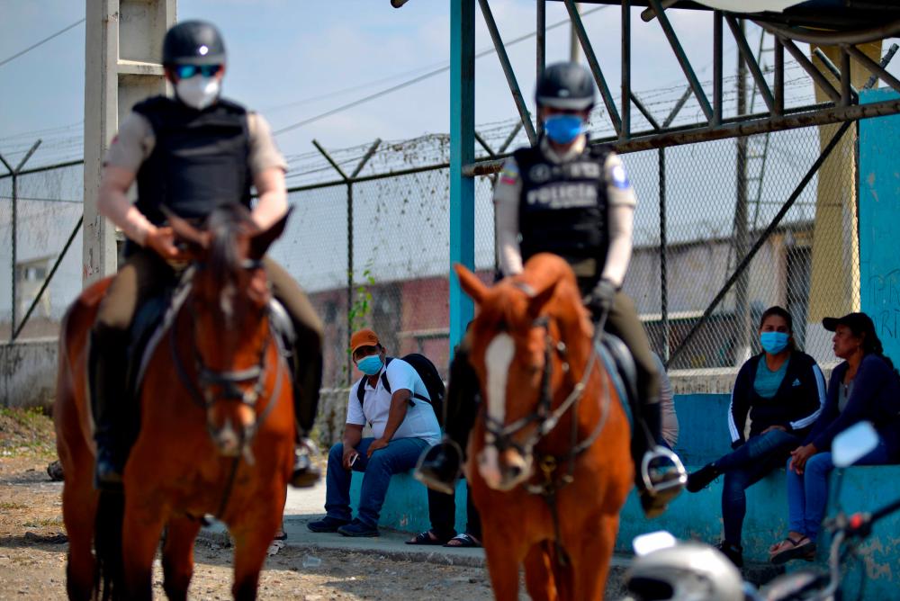 Relatives of inmates wait for information next to mounted police outside the Guayas 1 prison in Guayaquil, Ecuador, on September 30, 2021. AFPpix
