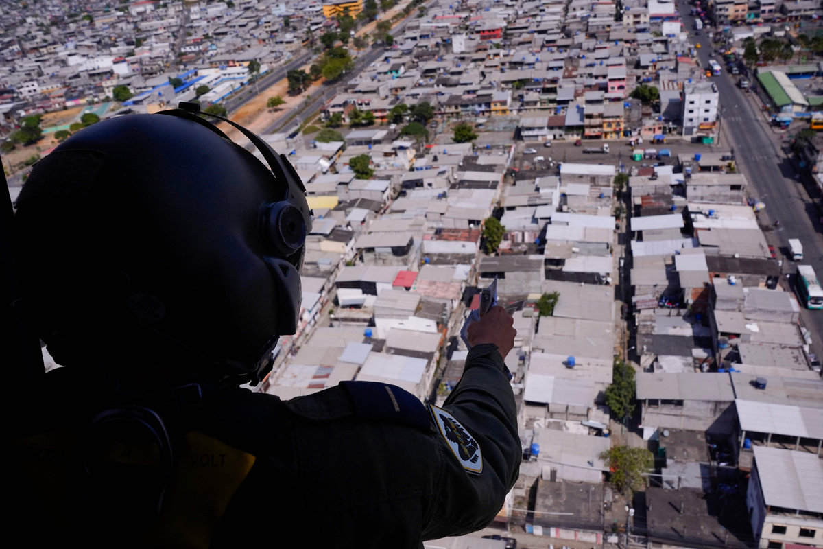 A member of Ecuadorian Army throws pamphlets from a helicopter with a telephone number to report criminal activity in Duran, Ecuador on June 13, 2025, as part of an initiative financially supported by the United States Southern Command to combat crime. - AFPpix