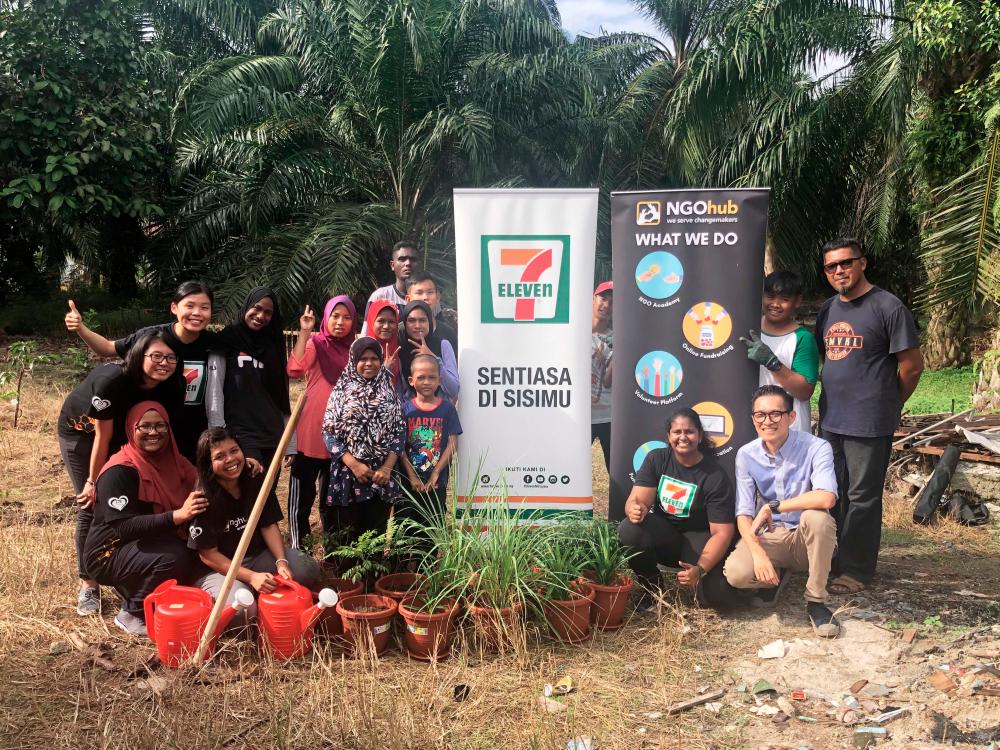 The children from PAKATS and volunteers from 7-Eleven Malaysia after planting the trees.
