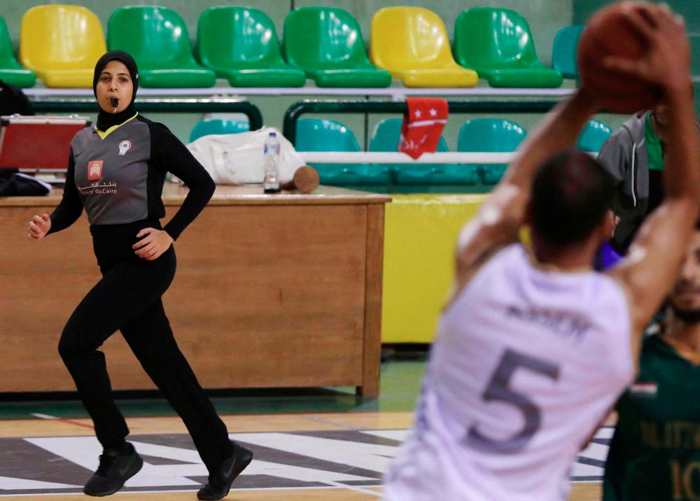 Egyptian Basketball referee Sarah Gamal (left) watches players during a match between the Al-Ittihad and Al-Geish teams at Al-Sakandari Arena in northern city of Alexandria, on April 17, 2021. – AFPPIX.