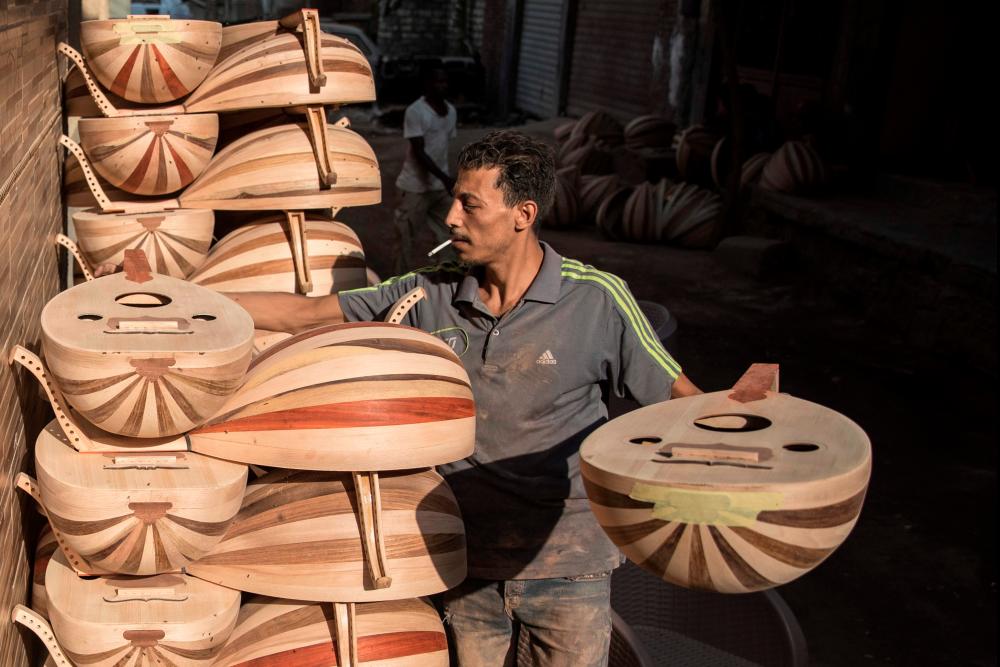 $!A man stacks Arabian Ouds at a workshop belonging to Khaled Azzouz, a veteran oud-maker at the al-Marg district on the outskirts of the Egyptian capital Cairo on October 26, 2020. The oud, a centuries-old stringed instrument popular in the Middle East, is a key element of classical Arabic music. Azzouz said he had observed “unprecedented interest” in the out during the global health pandemic. / AFP / Khaled DESOUKI