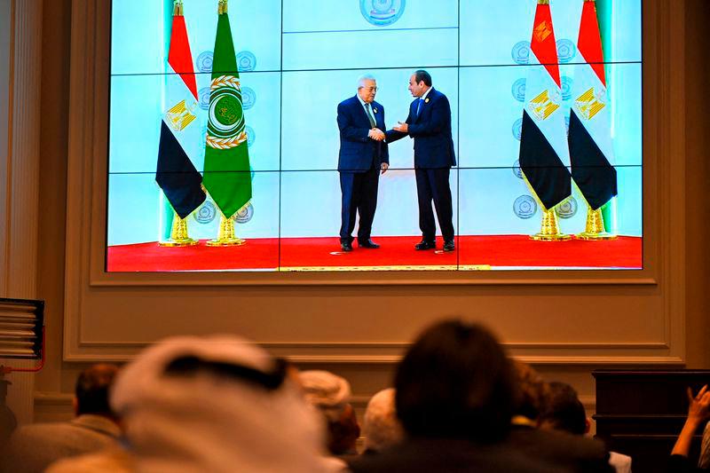 People watch on a big screen as Egypt’s President Abdel Fattah al-Sisi (R) welcomes Palestinian President Mahmud Abbas ahead of an Arab League summit on Gaza on March 4, 2025. AFP pix