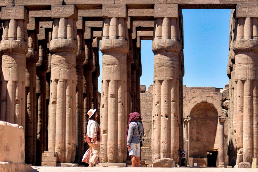 $!Tourists walk at the colonnade of the Temple of Luxor as they tour through the archaeological site in Egypt’s southern city of Luxor on July 1, 2020, as the country eases restrictions put in place due to the COVID-19 coronavirus pandemic. . / AFP /