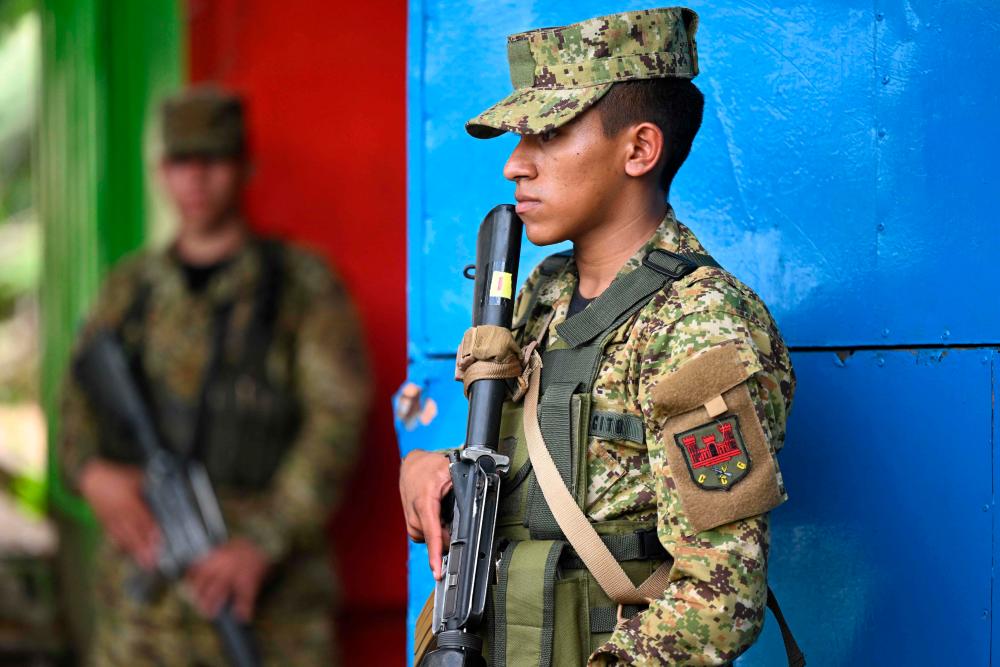 Soldiers stand guard in a community in Apopa, El Salvador, on October 11, 2023. AFPPIX