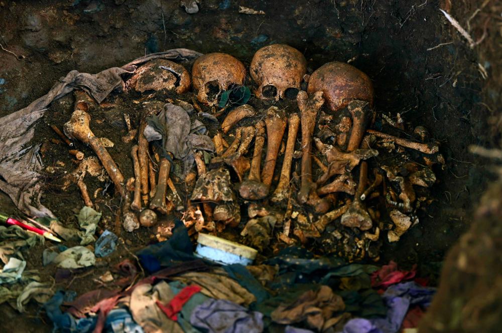 Human remains are seen as a team of international forensics work on their exhumation at the Yancolo hamlet, in Cacaopera, El Salvador, on Nov 6, 2019. — AFP