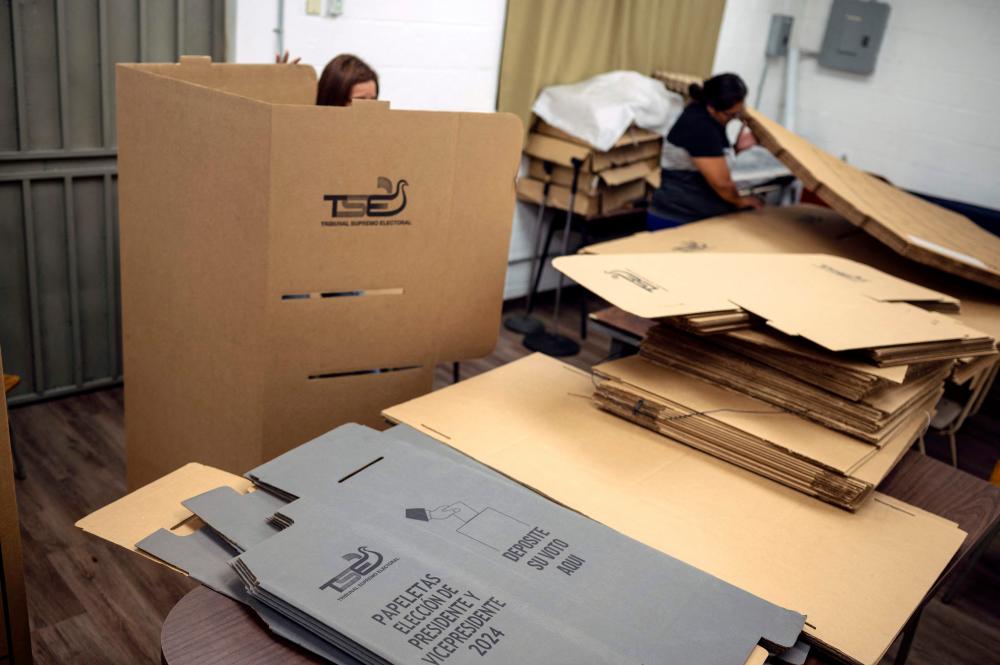 Employees of the Supreme Electoral Tribunal (TSE) work assembling electoral material that will be used at a polling station during the next presidential and legislative elections in Ayutuxtepeque, El Salvador. - AFPPIX