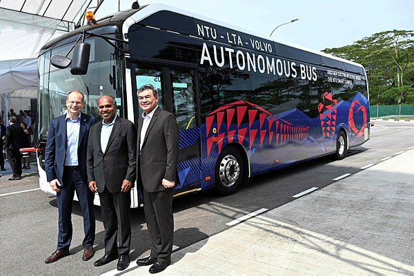 Nanyang Technology University President Subra Suresh (C), Volvo Buses President Hakan Agnevall (L) and Land Transport Authority Chief Innovation and Technology Officer, Lam Wee Shann (R) pose after unveiling Volvo’s first full size autonomous electric bus. — AFP