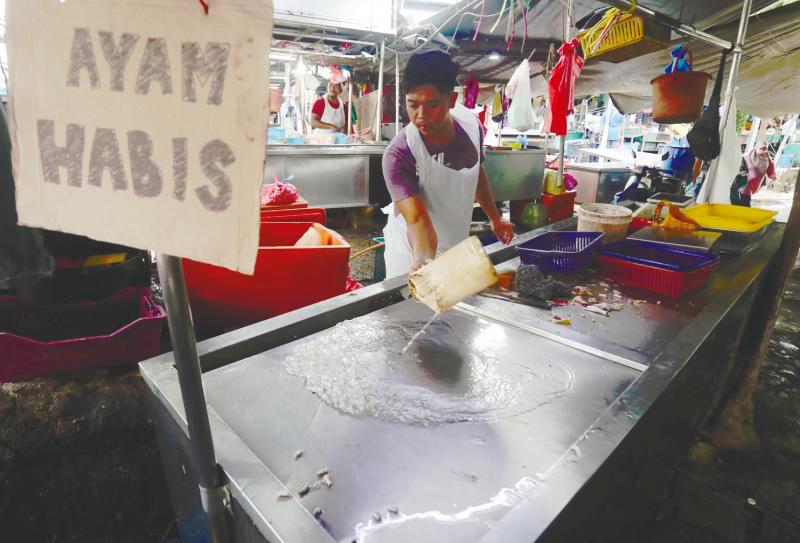 A trader washing up the area after supply of fresh poultry at his stall was sold out as early as 8am at the Bukit Mertajam market yesterday. – MASRY CHE ANI/THESUN