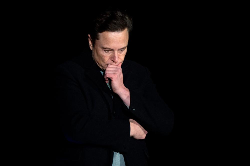 (FILES) In this file photo taken on February 10, 2022 Elon Musk pauses and looks down as he speaks during a press conference at SpaceX's Starbase facility near Boca Chica Village in South Texas. AFPpix