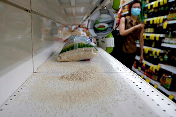 A packet of rice is pictured on an empty shelf as people stock up on food supplies, after Singapore raised coronavirus outbreak alert level to orange, at a supermarket in Singapore on Saturday. — Reuters