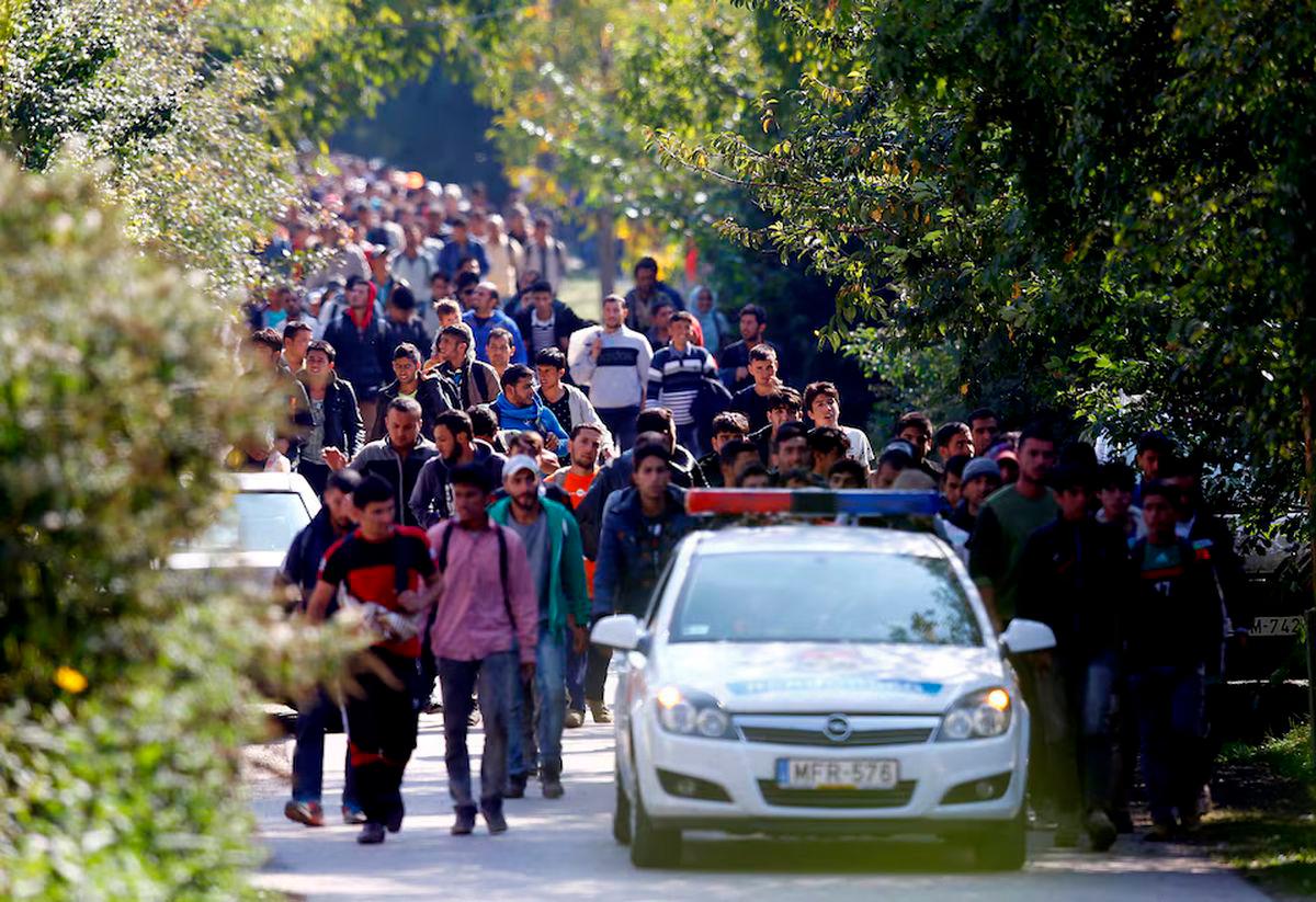 Migrants walk towards the Austrian border after they arrive by train in Hegyeshalom, Hungary September 23, 2015. REUTERS/Leonhard Foeger/File Photo