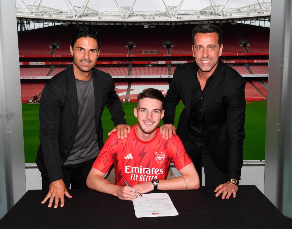 Declan Rice finalising the paperwork with Arsenal manager Mikel Arteta and sporting director Edu Gaspar. Pix credit: Twitter/@Arsenal