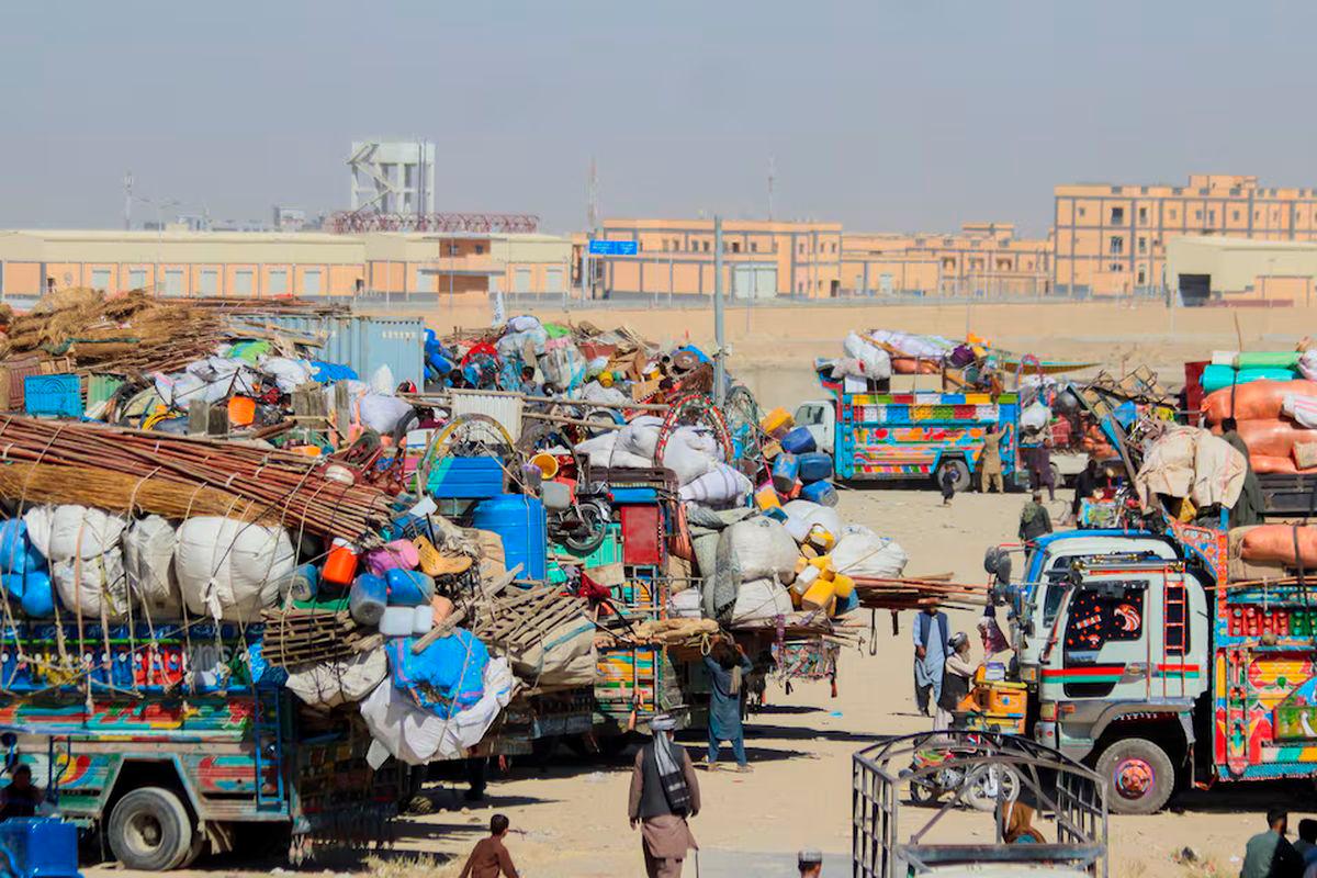 People walk past parked vehicles with belongings of Afghan citizens, as they head back to their country, after Pakistan closed border crossings with Afghanistan, following exchanges of fire between the forces of the two countries. REUTERS/Saeed Ali Achakzai