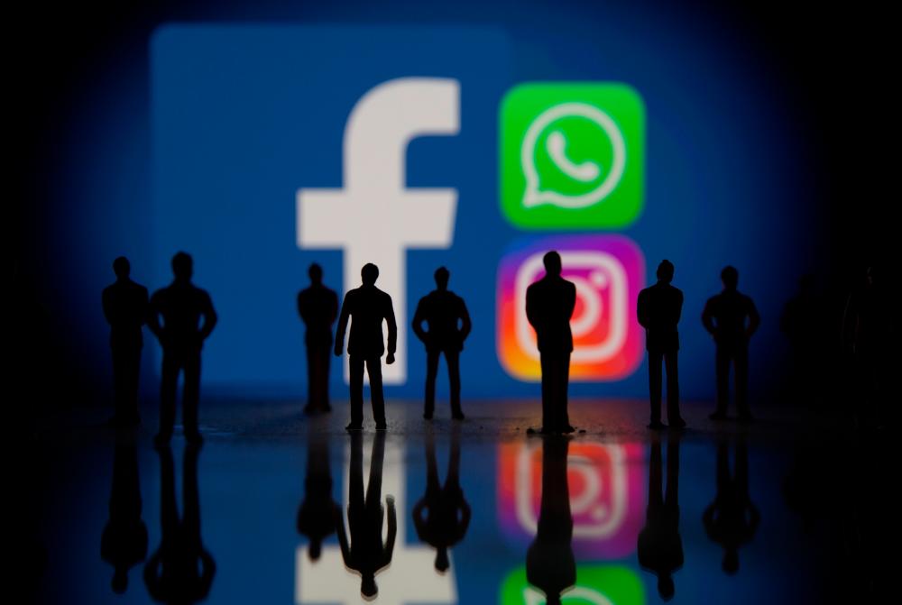 Small toy figures are seen in front of displayed Facebook, Whatsapp and Instagram logos in this illustration taken October 4, 2021. REUTERSpix