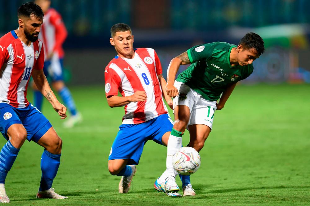 Paraguay’s Richard Sanchez (left) and Bolivia’s Roberto Carlos Fernandez vie for the ball during their Conmebol Copa America 2021 group phase match at the Olympic Stadium in Goiania, Brazil, on June 14, 2021. – AFPPIX