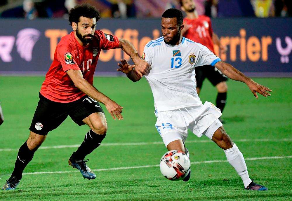 Egypt’s forward Mohamed Salah (L) fights for the ball with DR Congo’s forward Elia Meschak during the 2019 Africa Cup of Nations (CAN) football match between Egypt and DR Congo at the Cairo International Stadium on June 26, 2019. — AFP