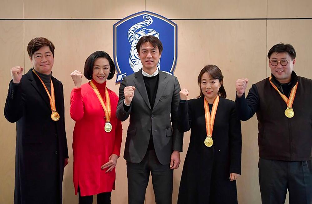 This handout photo taken on Jan 4, 2019 and provided by the Korea Football Association (KFA) shows KFA executive director Hong Myung-bo (C) and family members of four late South Korean football players posing with pure gold medals during a ceremony of the presentation in Seoul. — AFP